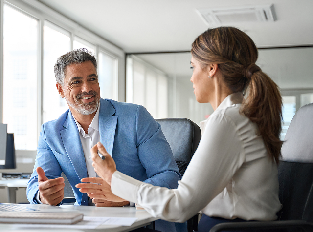cost_estimates - Axis Integrated Mental Health Two professionals in a bright office chat over documents at a table, smiling and engaged in a discussion.